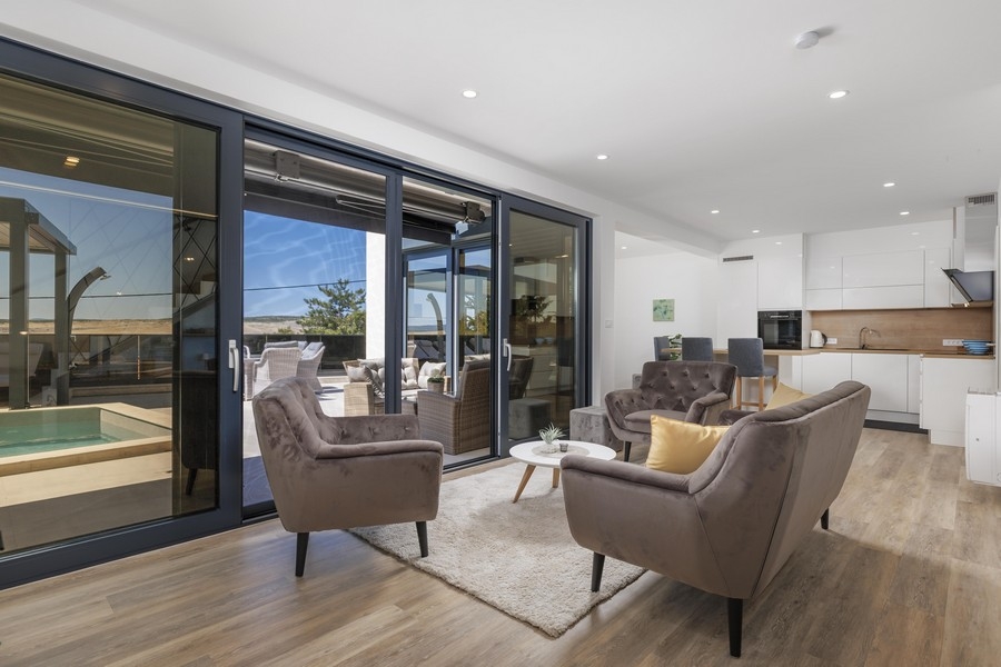 Modern nappali kilátással a teraszra és a medencére