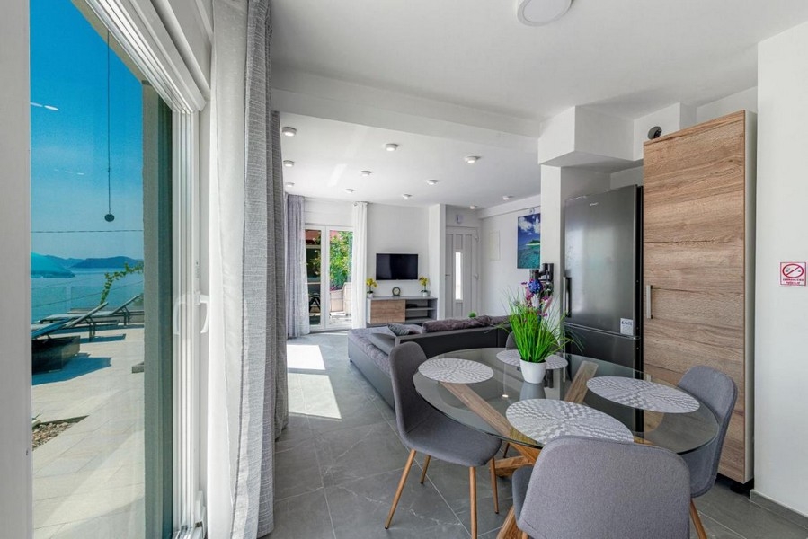 Étkező üvegasztallal és hozzáférés a tengerre néző teraszhoz