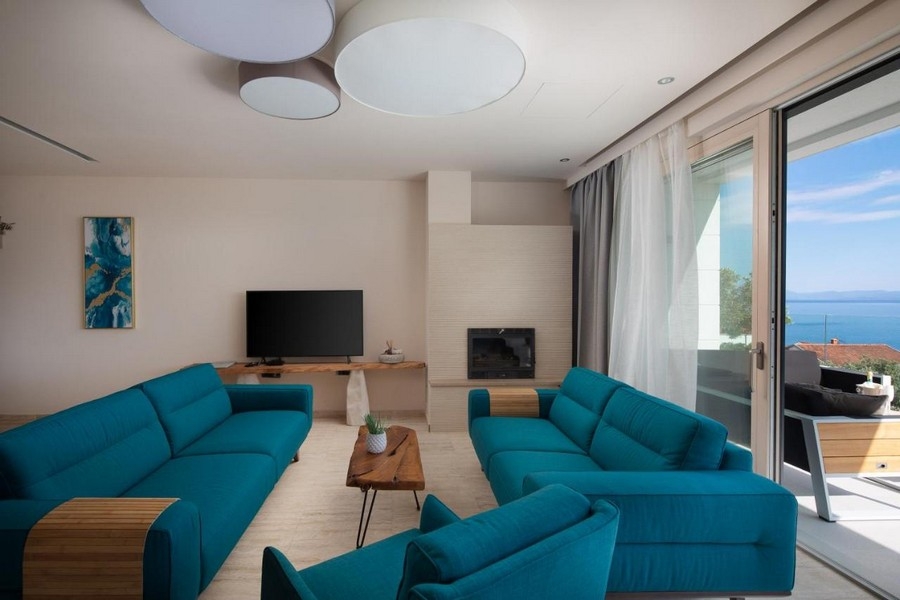 Modern nappali kék kanapékkal és kilátással a tengerre