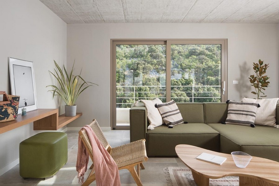 Modern berendezésű nappali kanapéval és nagy ablakokkal