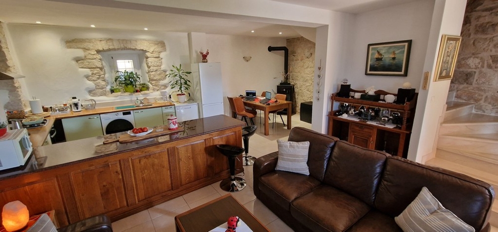 Nappali konyhával, étkezővel és természetes kőfallal