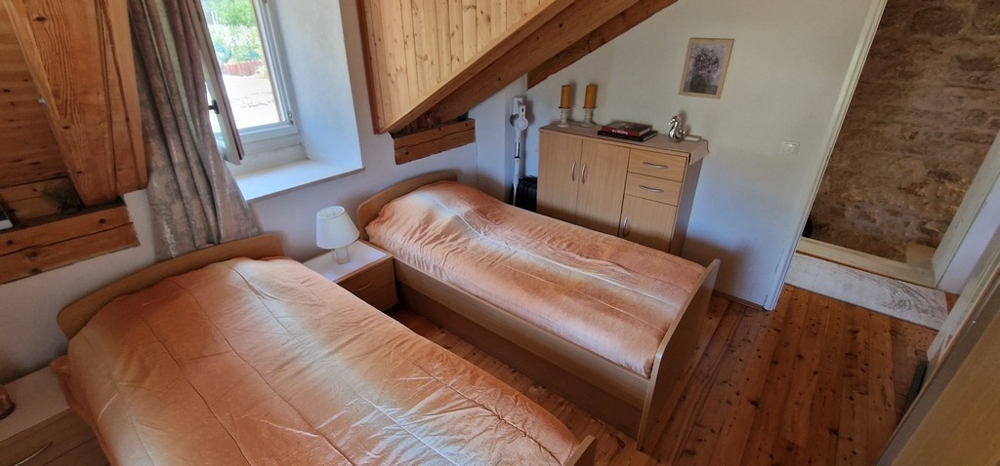 Hálószoba két egyszemélyes ággyal és fapadlóval