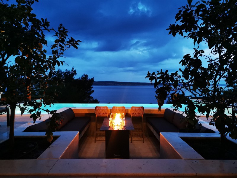 Társalgó tűzrakóval és kilátással a tengerre éjszaka