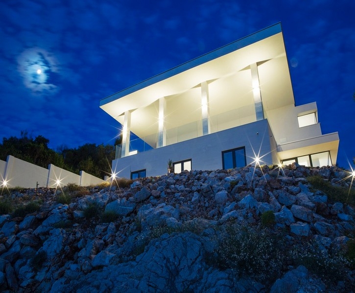 Modern villa Dubrovnik közelében, közvetlenül a tenger mellett éjszaka, világítással