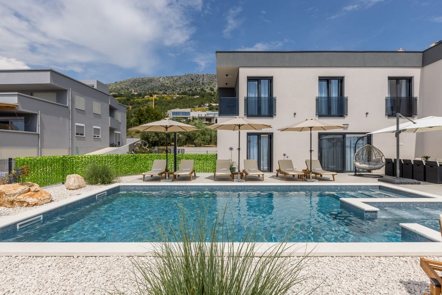 Medencére néző nyugágyakkal és modern villával