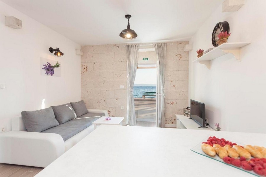 Világos nappali kanapéval és kilátással a tengerre