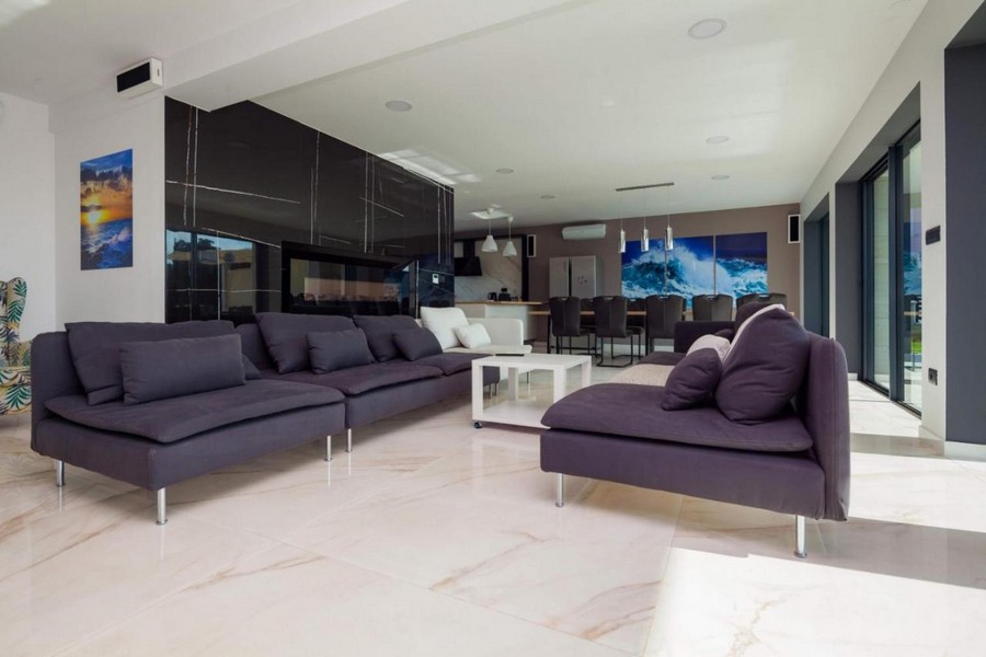 Tágas nappali padlótól a mennyezetig érő ablakokkal és modern bútorokkal