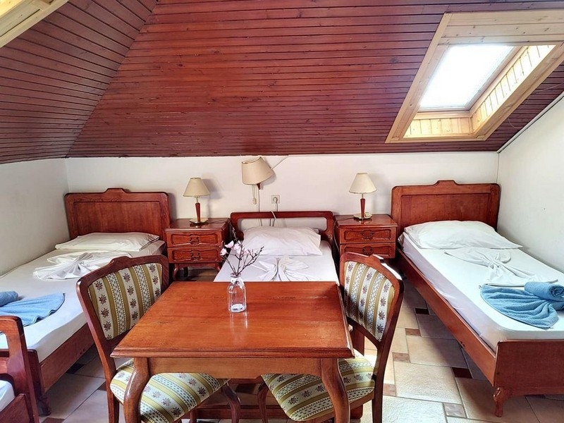 Háromágyas szoba a tetőtérben fabútorokkal