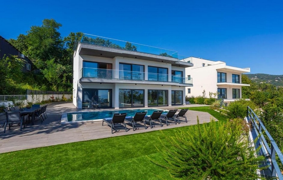 Modern villa medencével és napozóterasszal egy domboldalon