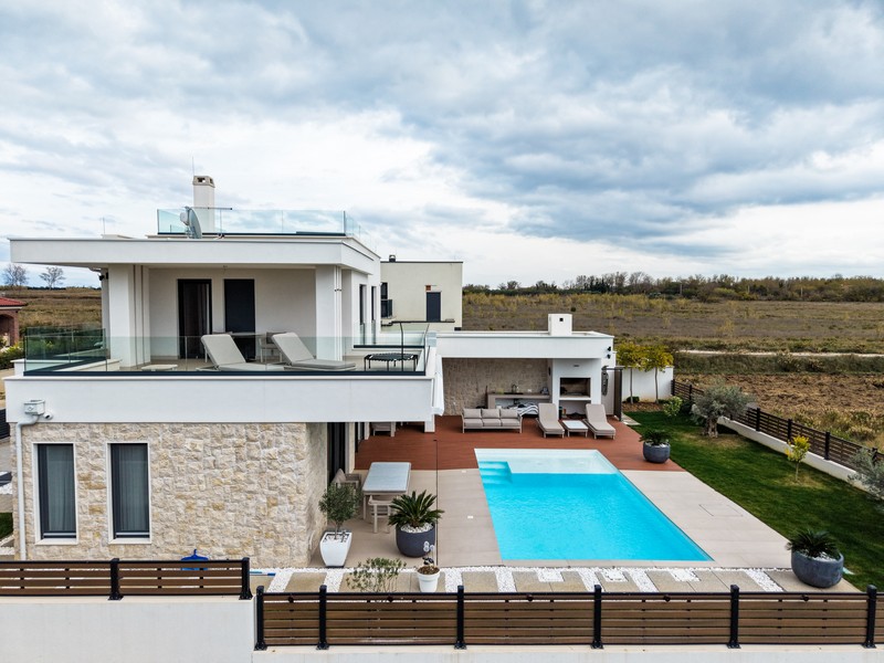 Oldalnézetből a villa nagy terasszal és medencével