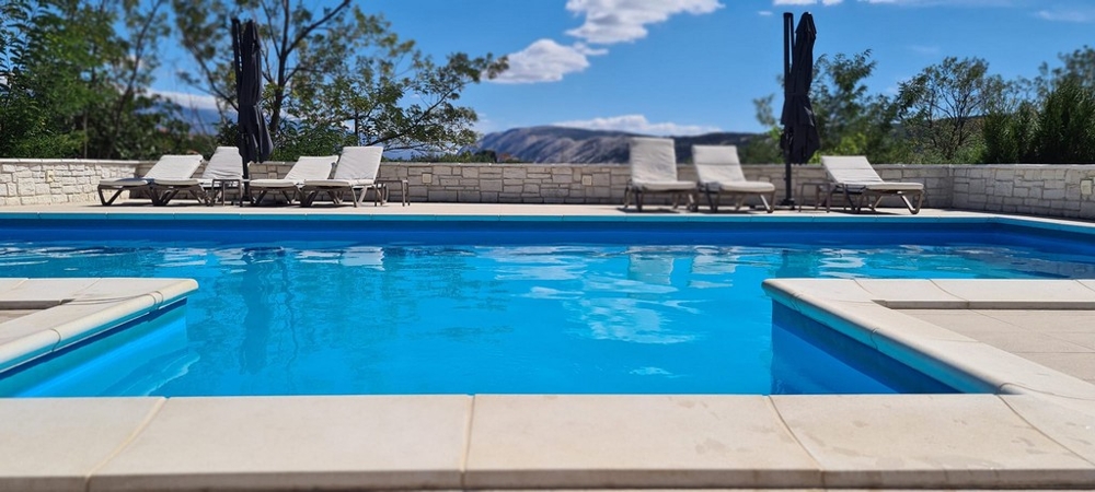 Medencerész nyugágyakkal és napernyőkkel a Villa H3768-ban Rabon