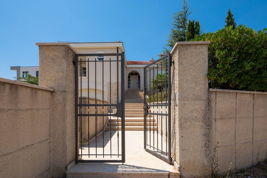 Kert és ház bejárata nyitott kapuval