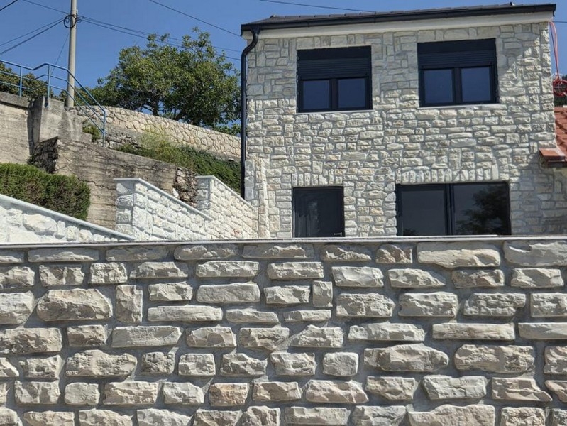 A horvátországi H3771 ház természetes kőfalával rendelkező kőház külső nézete