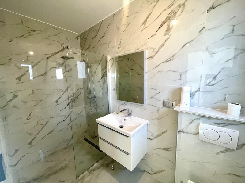 Modern fürdőszoba zuhanyzóval és mosdóval