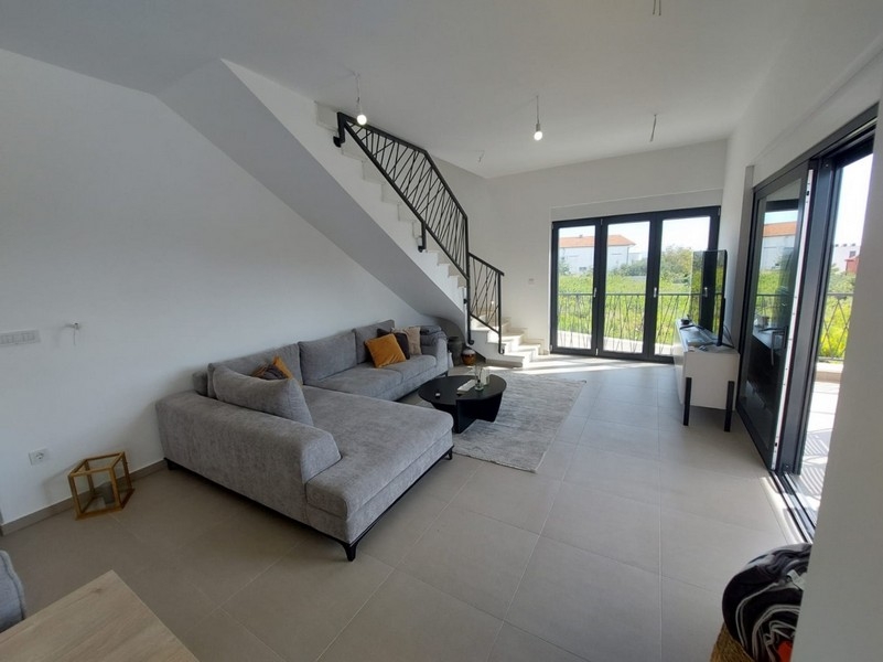 Világos nappali kanapéval és lépcsőkkel