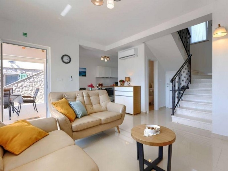 Nappali kanapéval, lépcsőkkel és kijárattal a teraszra