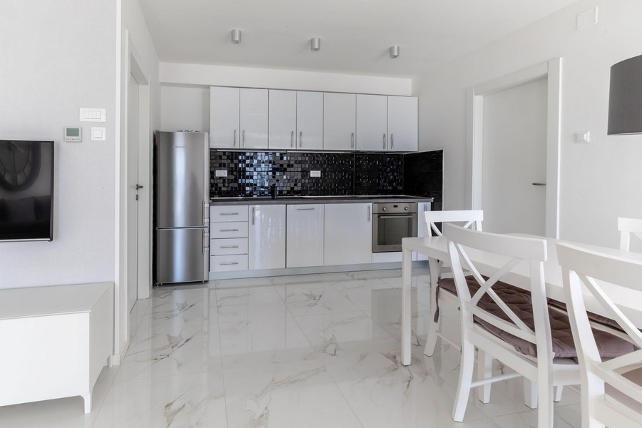 Modern konyha fehér felszerelt konyhával és étkezővel