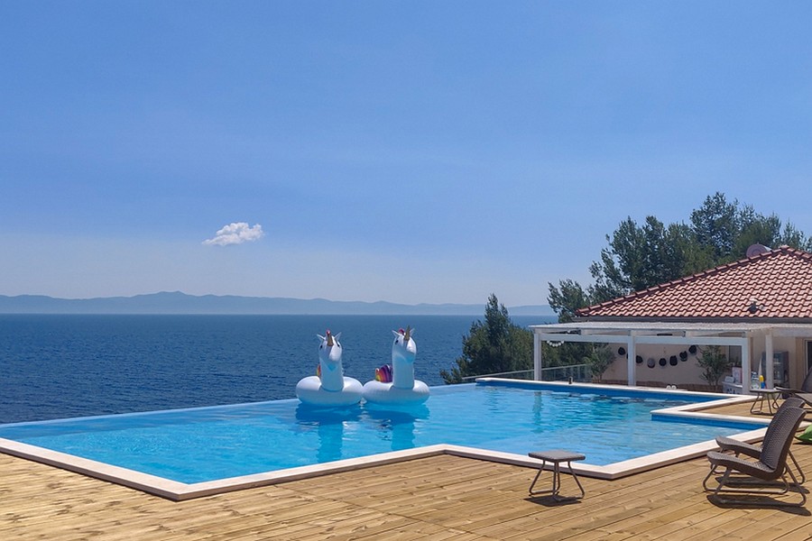 Végtelenített medence tengerre néző kilátással és tágas, fából készült terasszal