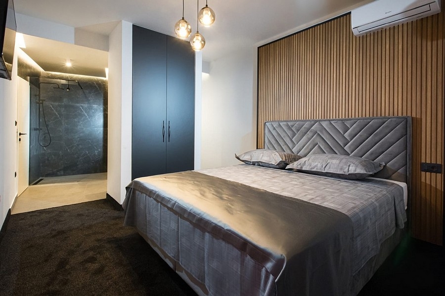 Hálószoba fa panelfallal és beépített zuhanyzóval