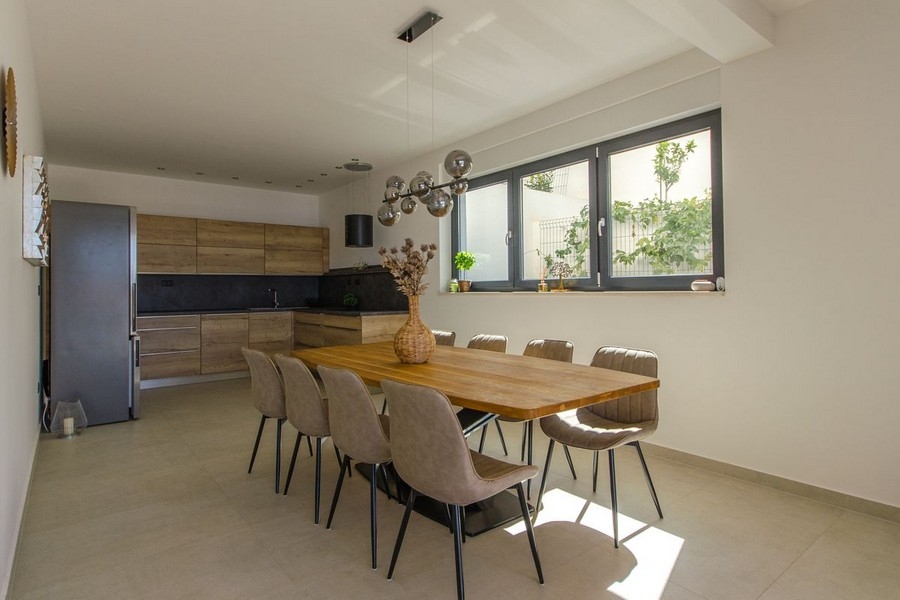 Étkező nagy fából készült asztallal és modern világítással