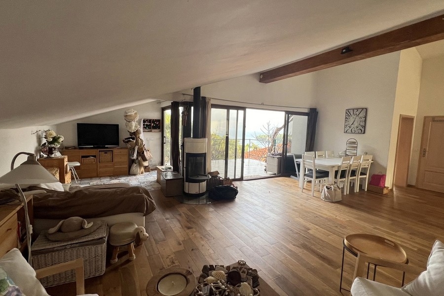 Nyitott nappali és étkező kandallóval és panoráma ablakokkal