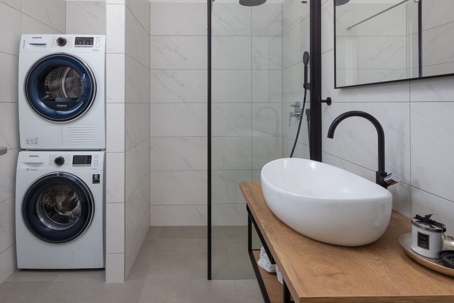 Modern fürdőszoba zuhanyzóval és mosógéppel