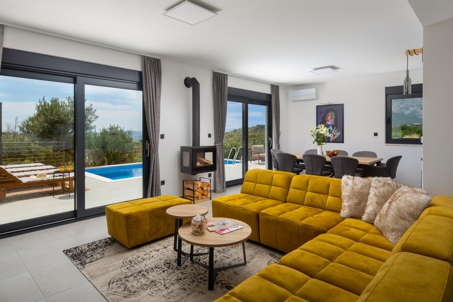 Nappali kanapéval, kandallóval és hozzáféréssel a medence teraszához