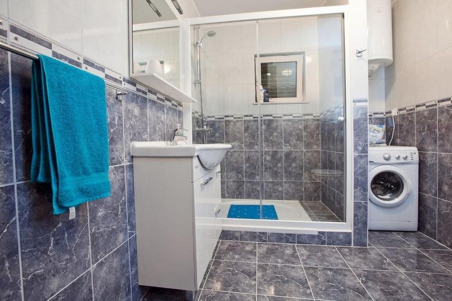 Fürdőszoba zuhanyzóval és mosógéppel