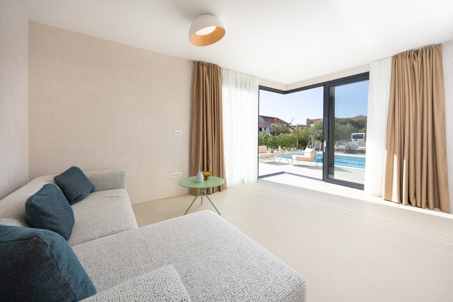 Nappali kanapéval, kilátással a teraszra és a medencére