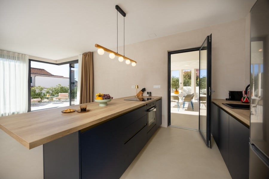 Modern konyha főzőszigettel és kijárattal a teraszra