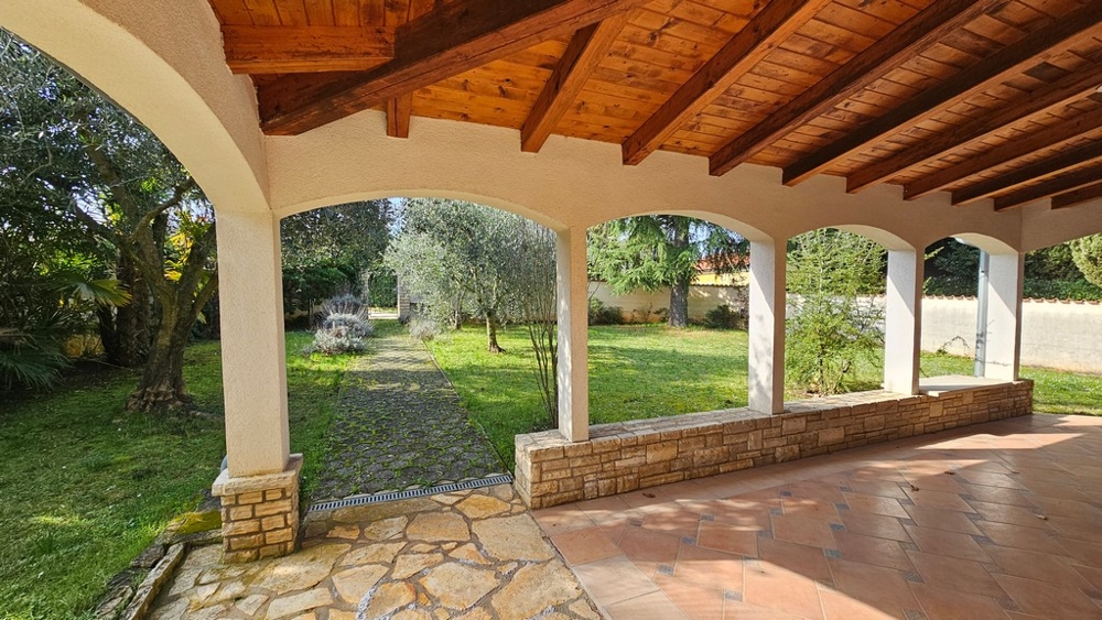 Fedett terasz ülősarokkal és kilátással a kertre