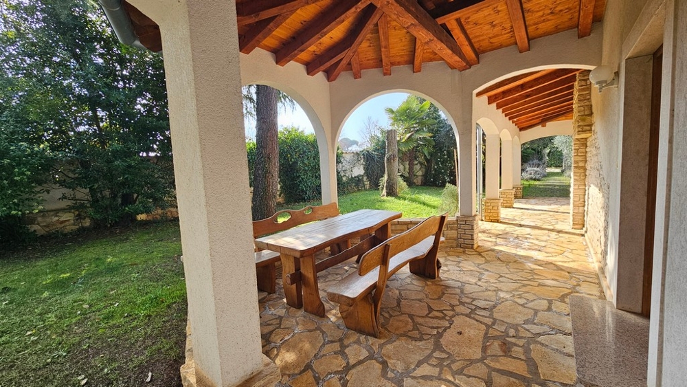 Nagy fedett terasz kerttel és árkádokkal