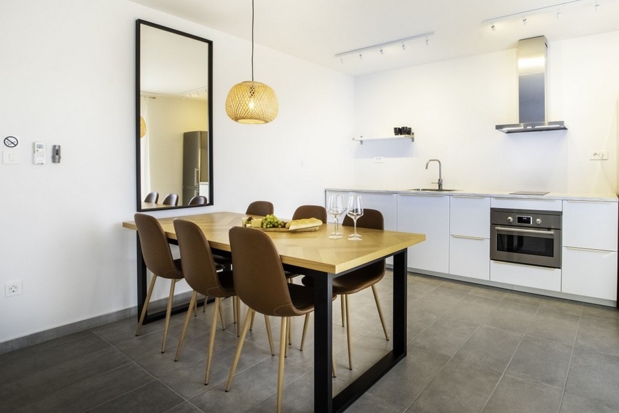 Nyitott konyha étkezőasztallal és modern felszerelt konyha