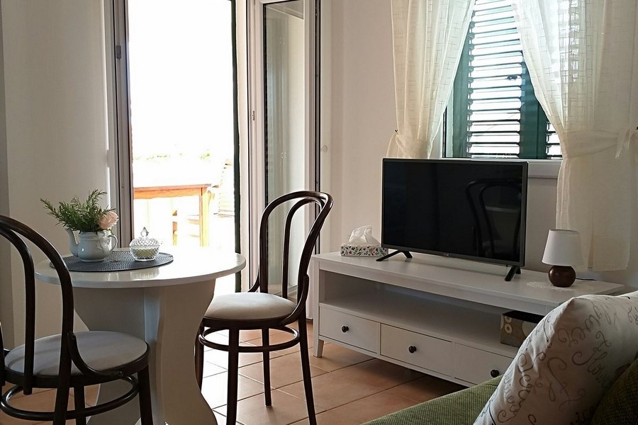 Nappali étkezőasztallal és kijárat a teraszra