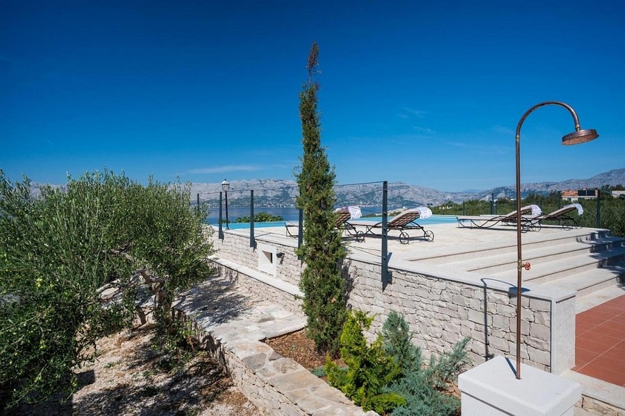 Terasz végtelenített medencével és panorámás kilátással a tengerre és a tengerpartra