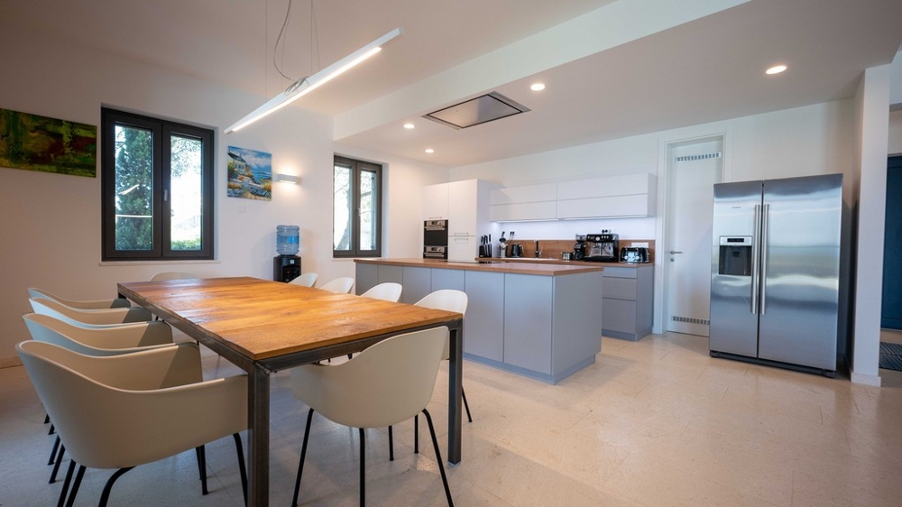 Modern konyha főzőszigettel és nagy étkezőasztallal