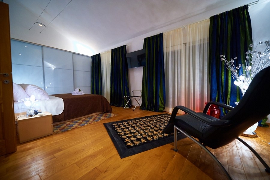 Tágas hálószoba parkettával és ülősarokkal