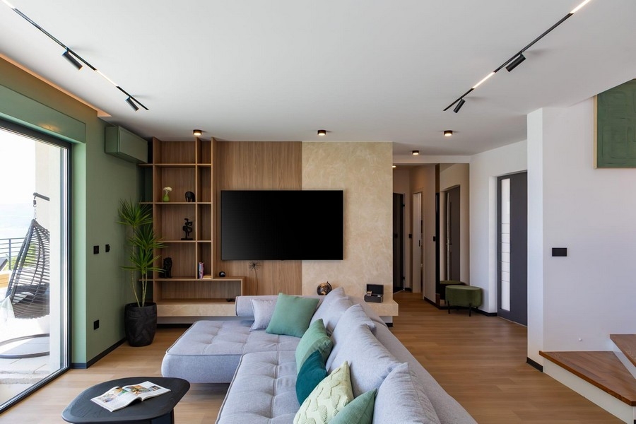 Nyitott nappali TV-fallal és dizájnos lépcsőházzal