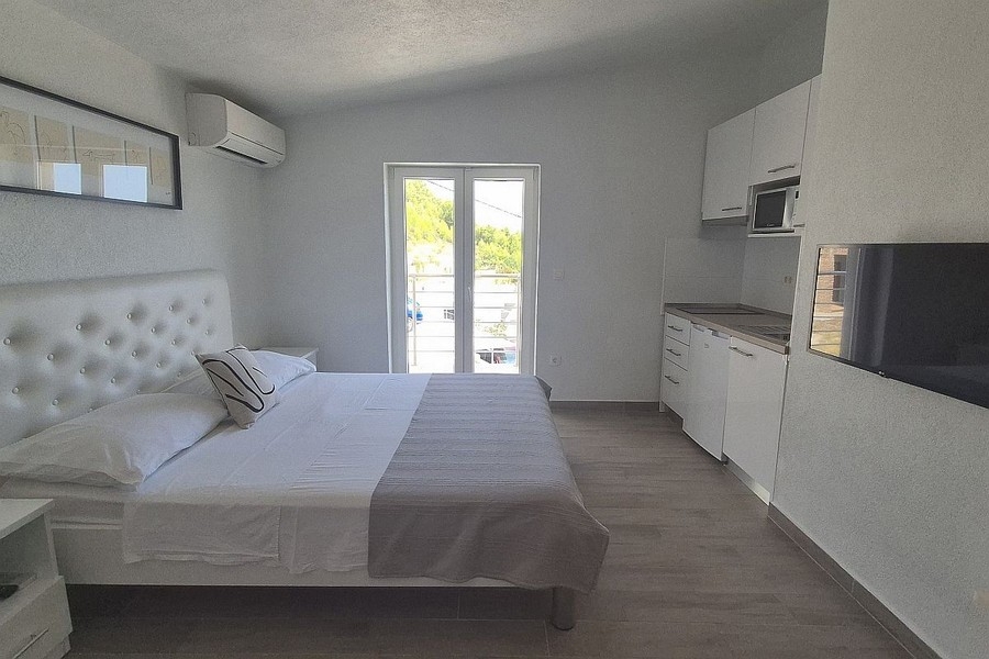 Világos stúdióapartman konyhasarokkal és erkéllyel