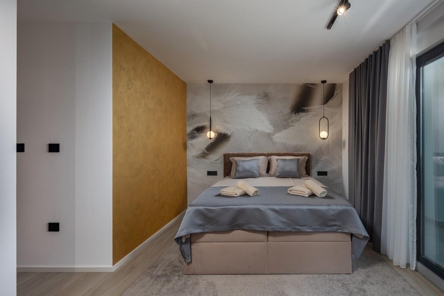 Kényelmes hálószoba stílusos falkialakítással