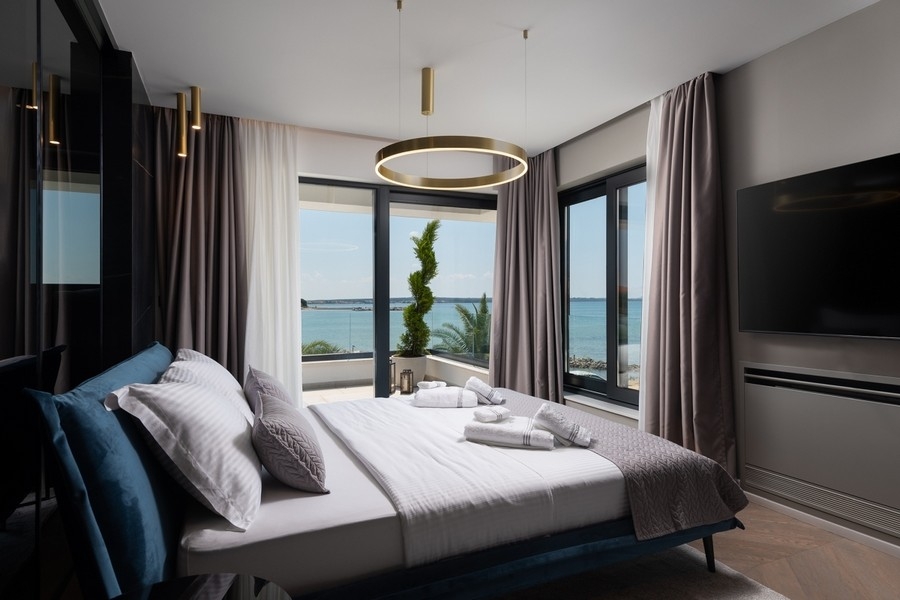 Hálószoba nagy ablakokkal és kilátással a tengerre Horvátországban