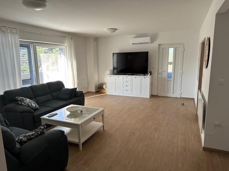 Nappali kanapéval, TV-vel és kijárattal az erkélyre, modern bútorokkal