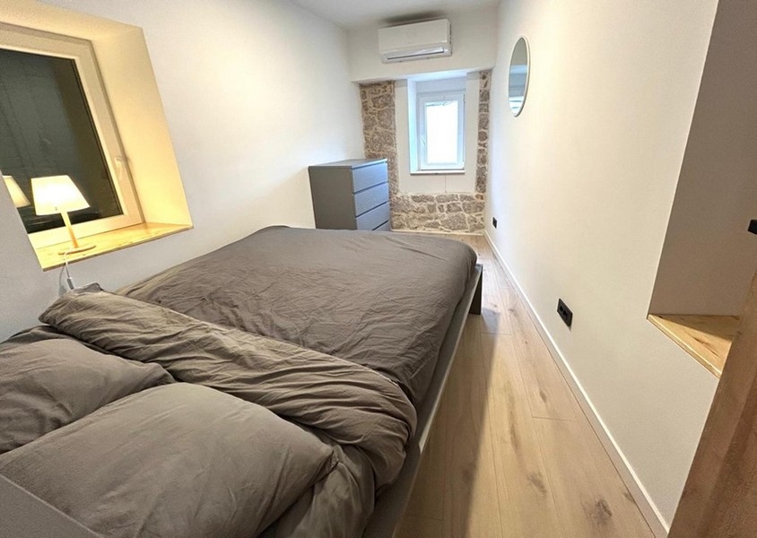 Hálószoba franciaággyal és látható természetes kőfallal