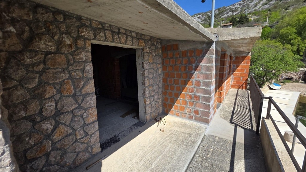 Természetes kőfallal és fedett terasszal rendelkező szabadtéri rész