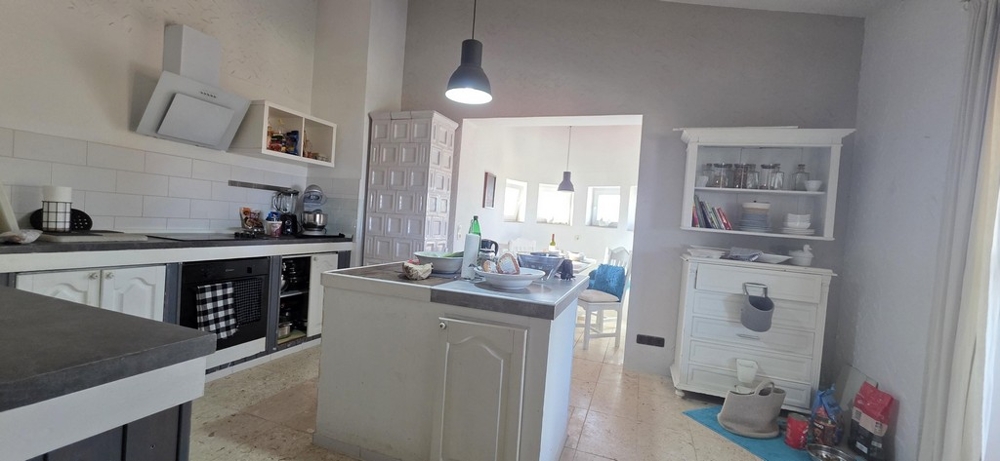 Konyha főzőszigettel és a hozzá tartozó nappalival