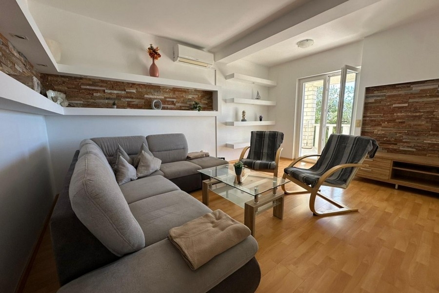 Nappali kanapéval, fotellel és modern falkialakítással