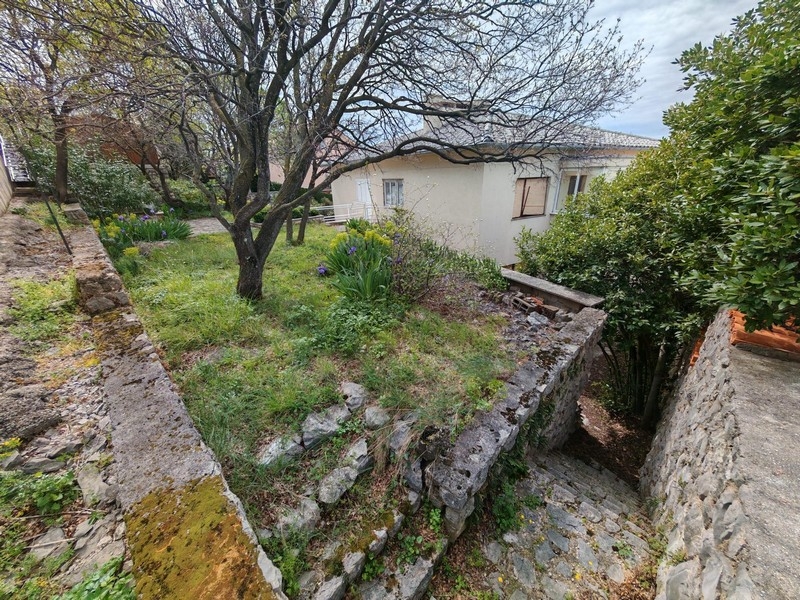 Lépcső vezet le a házhoz.