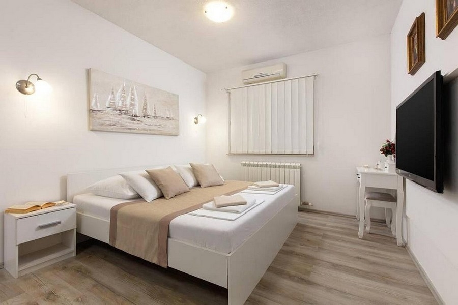 Modern berendezésű hálószoba légkondicionálóval és TV-vel