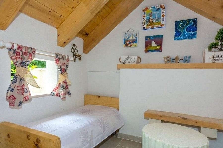 Hálószoba a tetőtérben fagerendákkal és hangulatos légkörrel