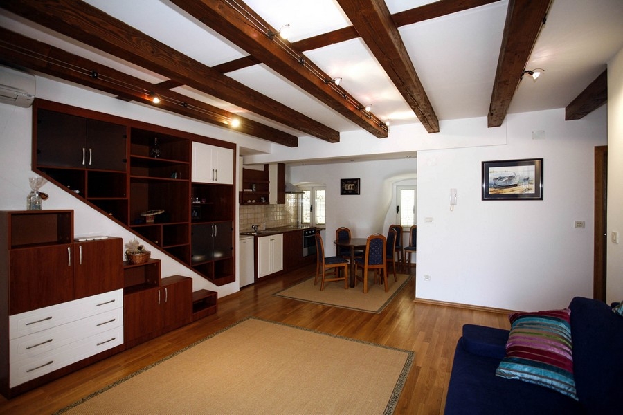 Nyitott nappali felszerelt konyhával és fa mennyezettel